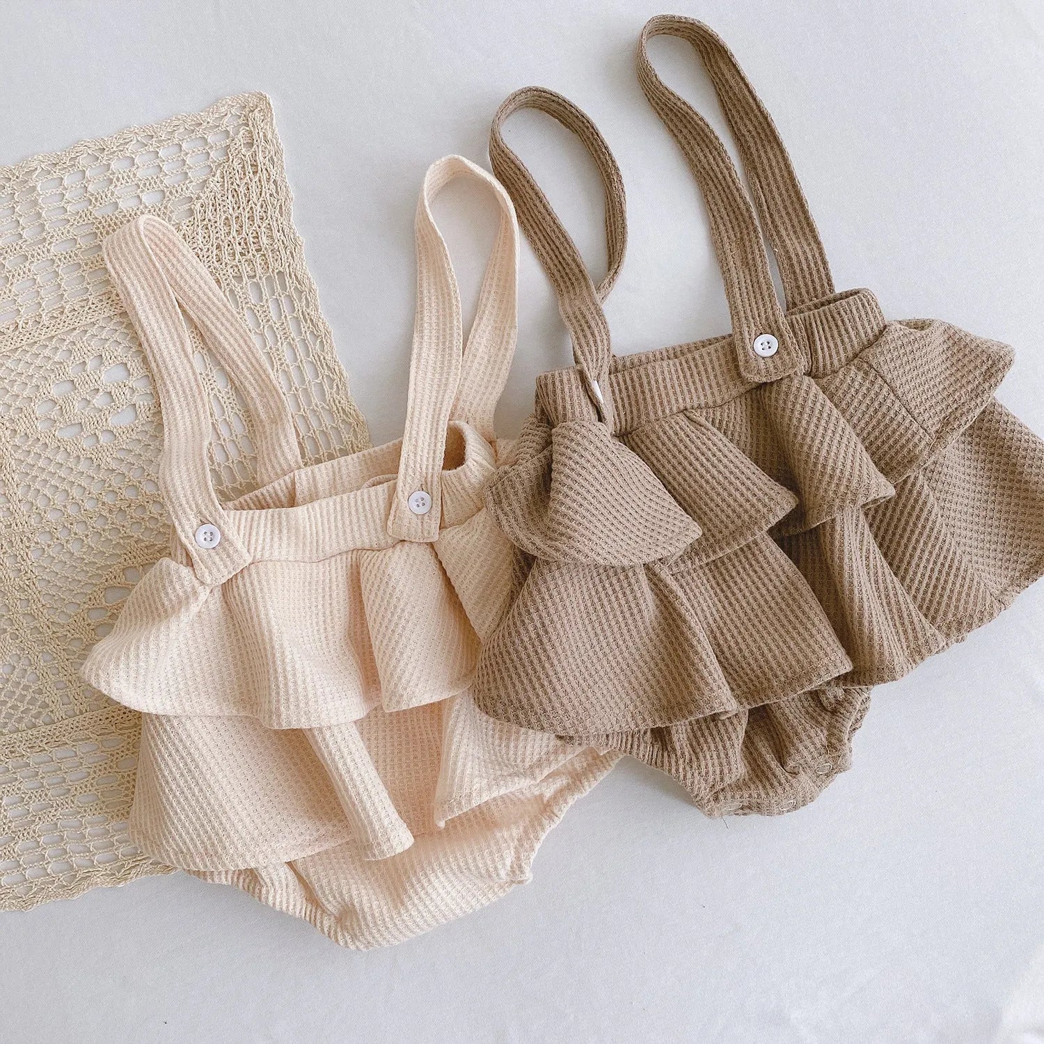 Baby romper with triangle climb style in cotton fabric showing apricot, coffee, floral and check colour options