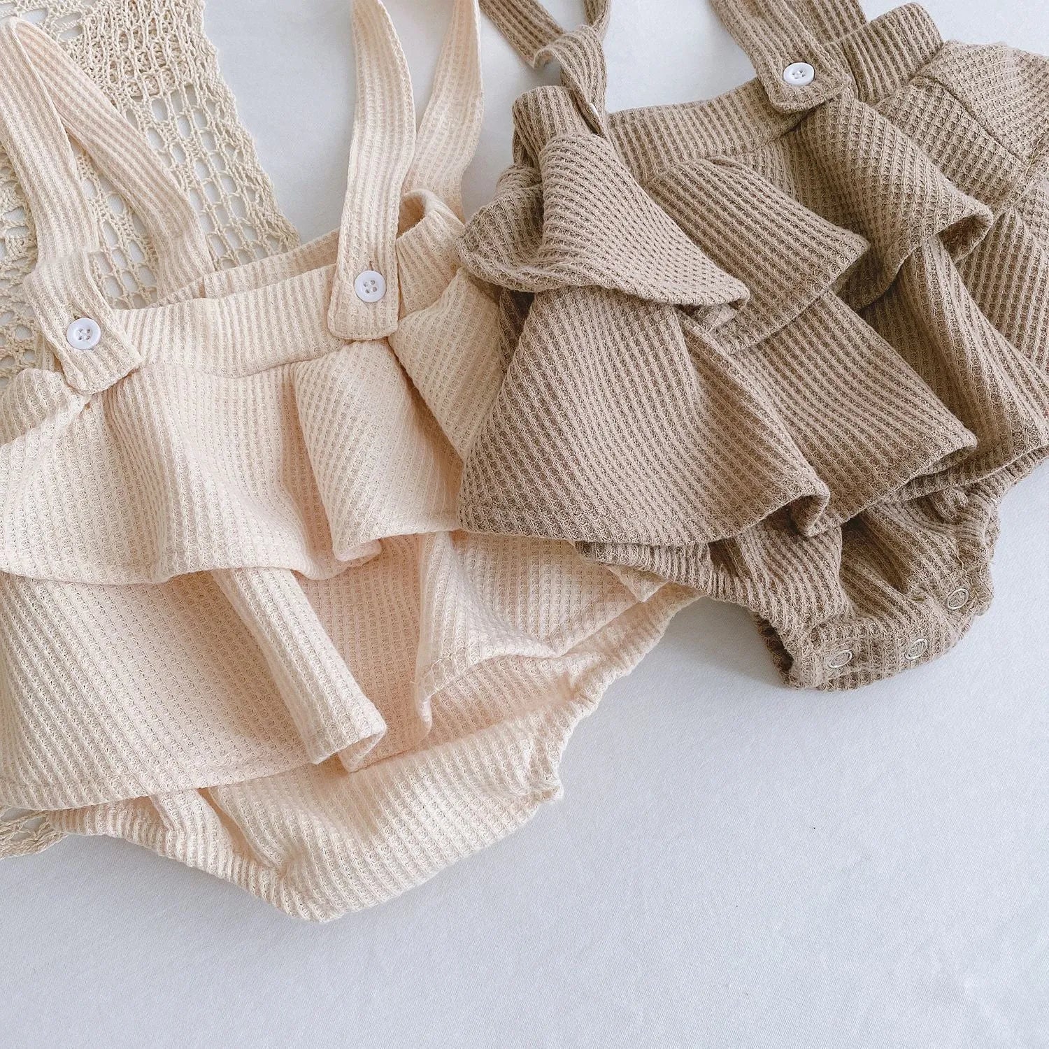 Baby romper with triangle climb style in cotton fabric showing apricot, coffee, floral and check colour options