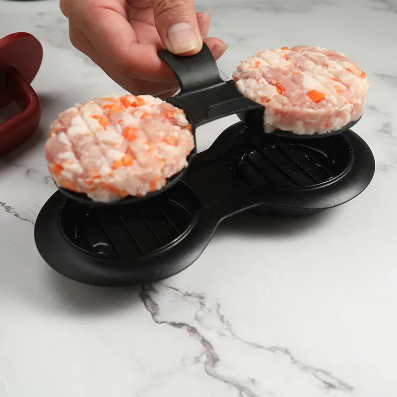 Black and red food-grade ABS plastic burger press mould on a kitchen counter.