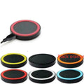 Square Qi wireless charging base in six colour options on a wood surface.