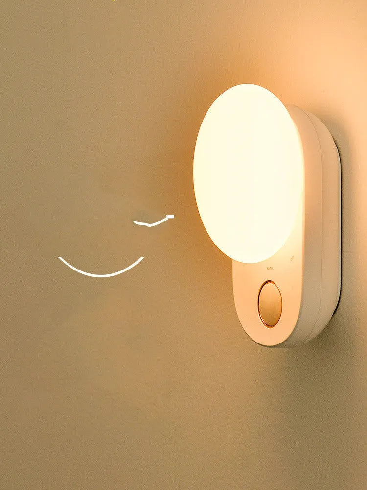 White Baseus rechargeable motion sensor bedside night light on a wooden surface.