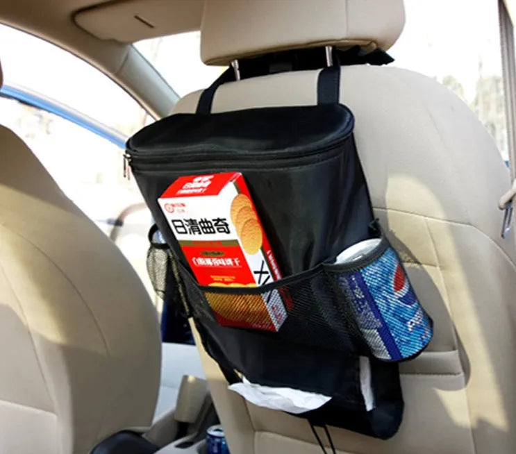 Black 600D Oxford cloth car trash storage bag with adjustable shoulder strap hanging on headrest