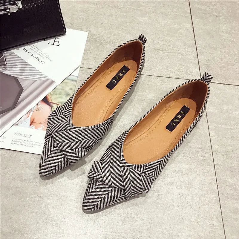 Red and black women's pointed toe shallow-mouth flats with a low flat heel on a white background.