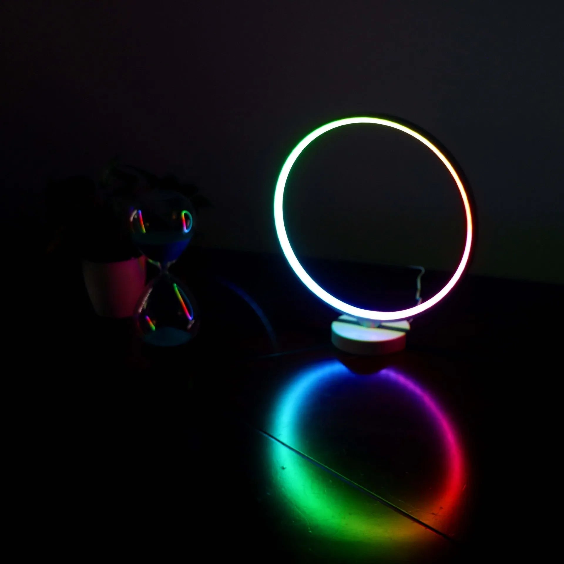White Full Moon table lamp with remote control on a wooden surface, showing its round silicone diffuser and aluminium base.