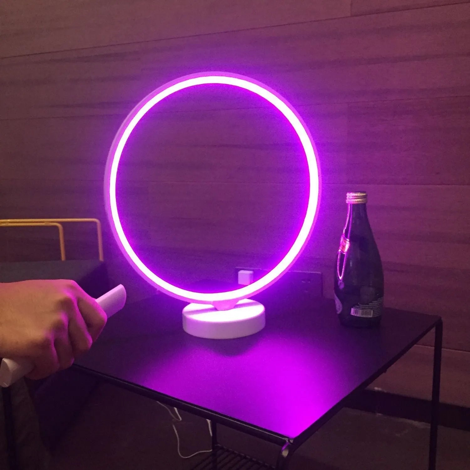 White Full Moon table lamp with remote control on a wooden surface, showing its round silicone diffuser and aluminium base.