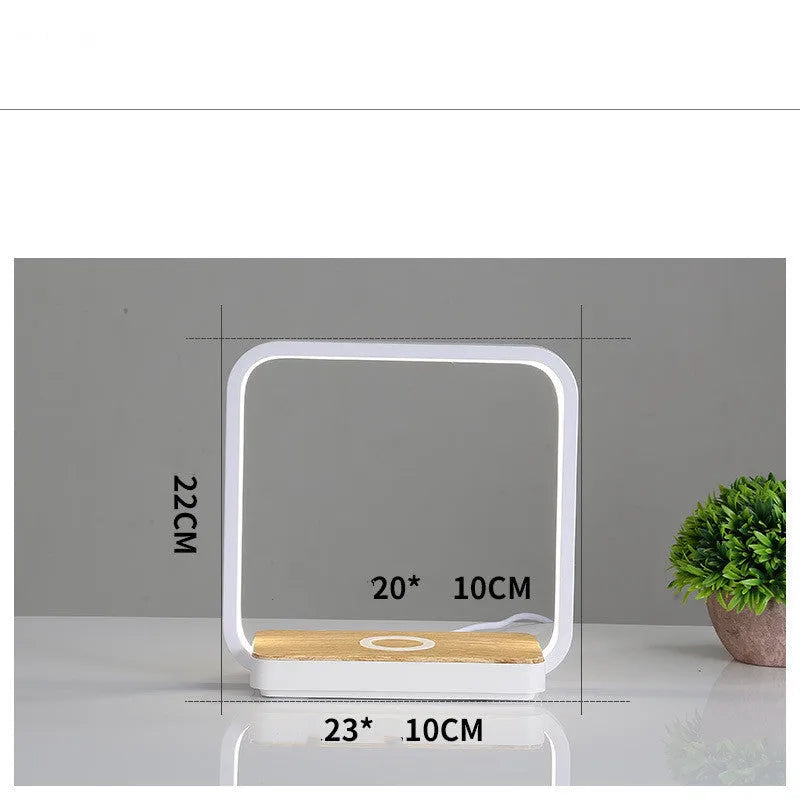 Modern white and gold smart bedside lamps with voice control and USB cable on a wooden table.