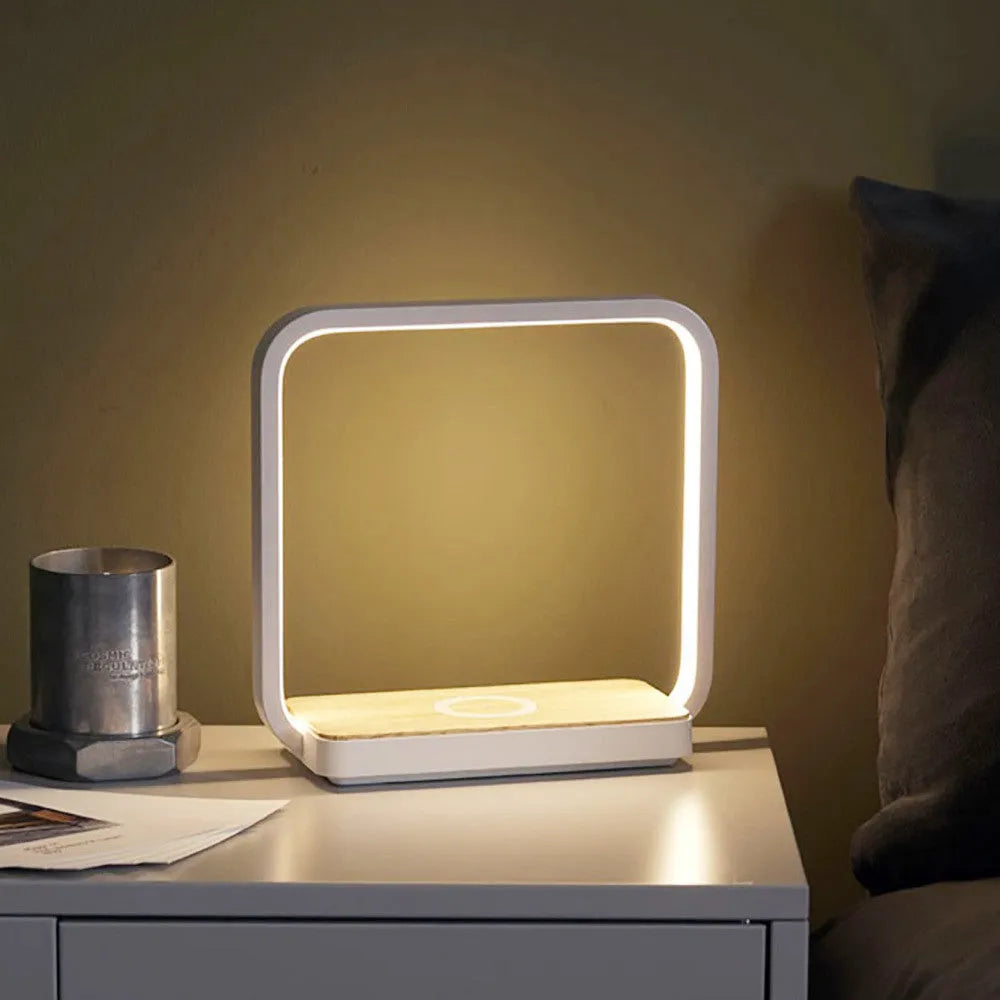Modern white and gold smart bedside lamps with voice control and USB cable on a wooden table.