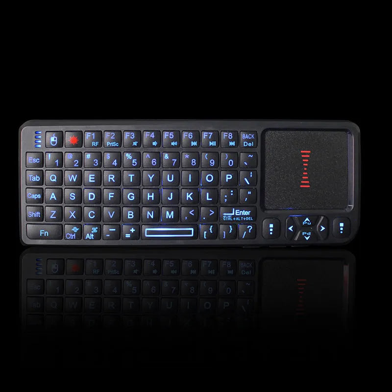 Black wireless mini keyboard with laser pointer, touch screen, and backlit keys on a desk.
