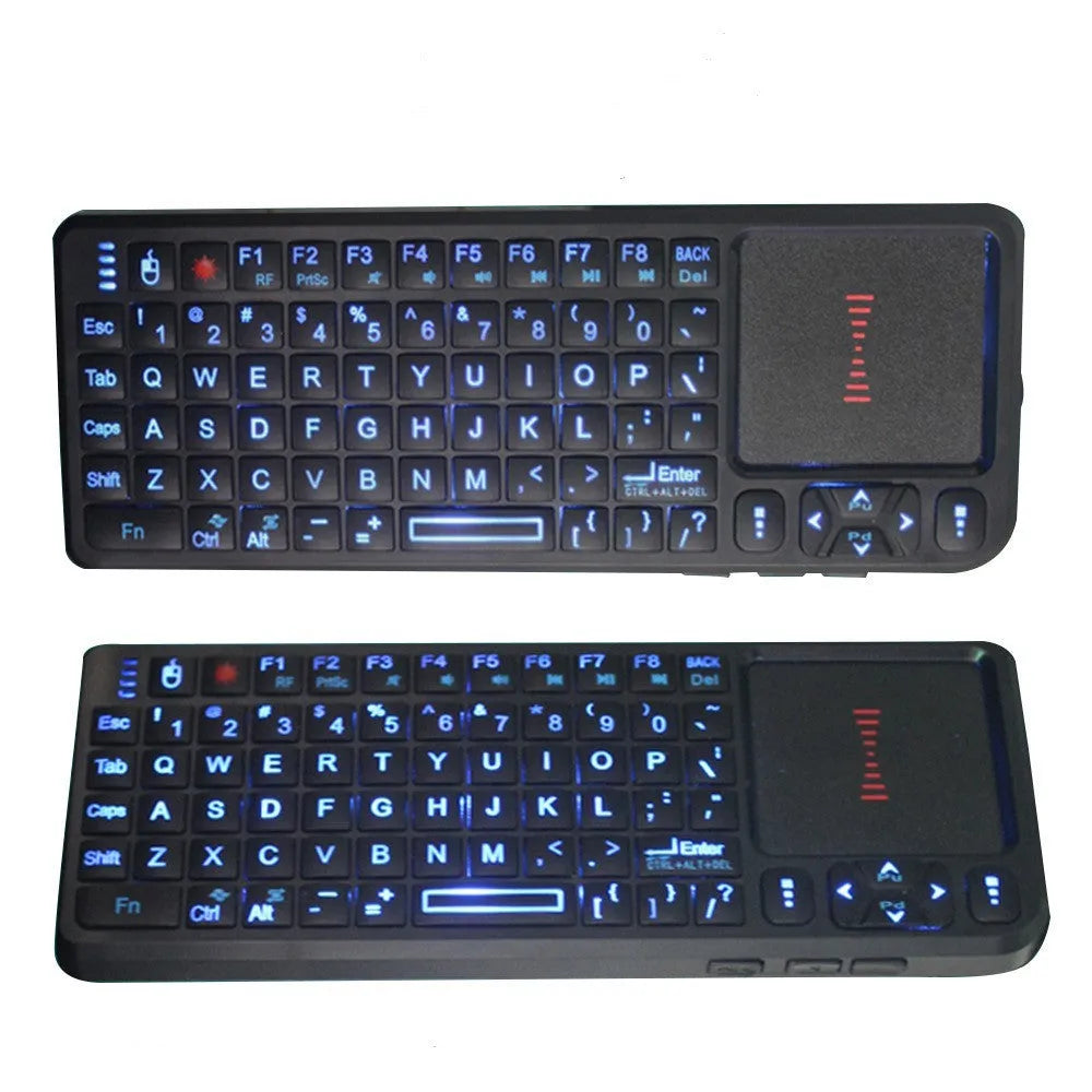 Black wireless mini keyboard with laser pointer, touch screen, and backlit keys on a desk.