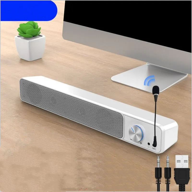Small black or white G18 desktop computer speaker with USB cable on a wooden desk.