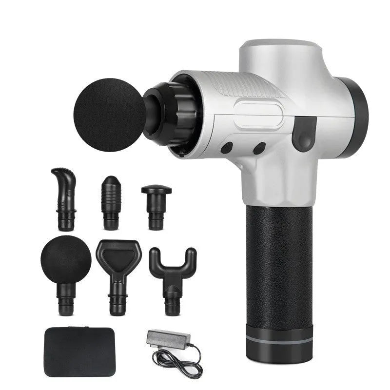 Black electric muscle massage gun with multiple interchangeable heads on a table.