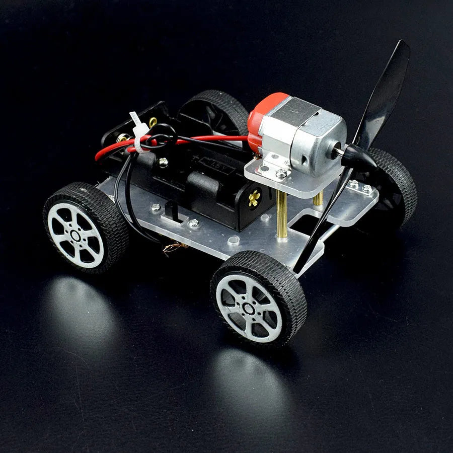 DIY wind car electronic experiment kit with acrylic, metal and plastic parts for children's science education.