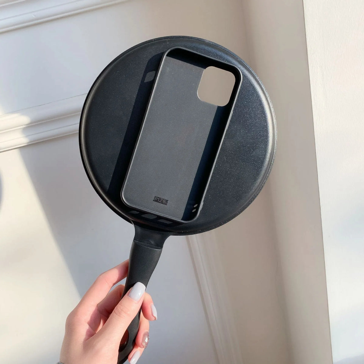 Black 3D frying pan shape iPhone case made of soft TPU and PC, back cover design.