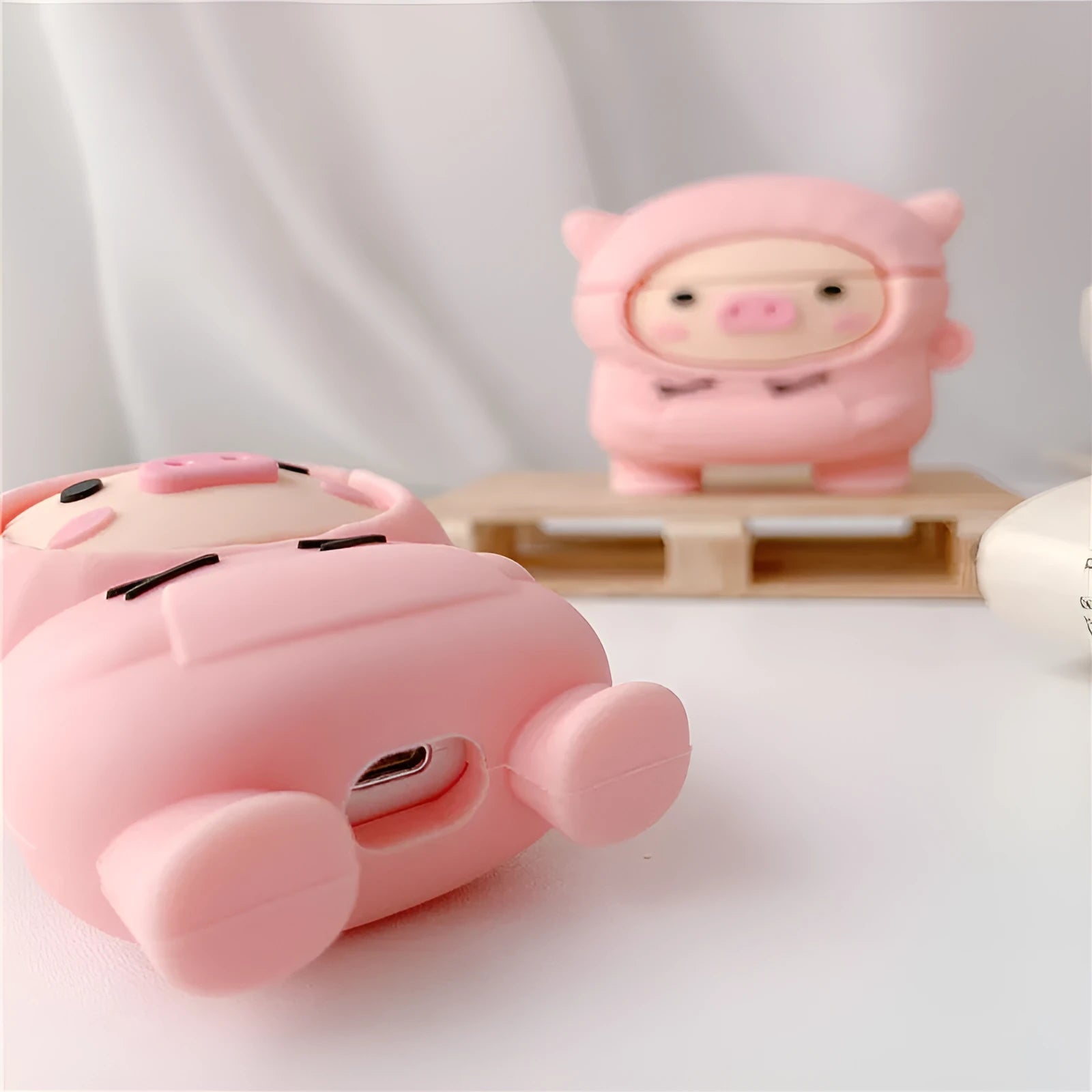 Silicone AirPods case with flip cover showing cartoon pink pig design compatible with Apple wireless headphones