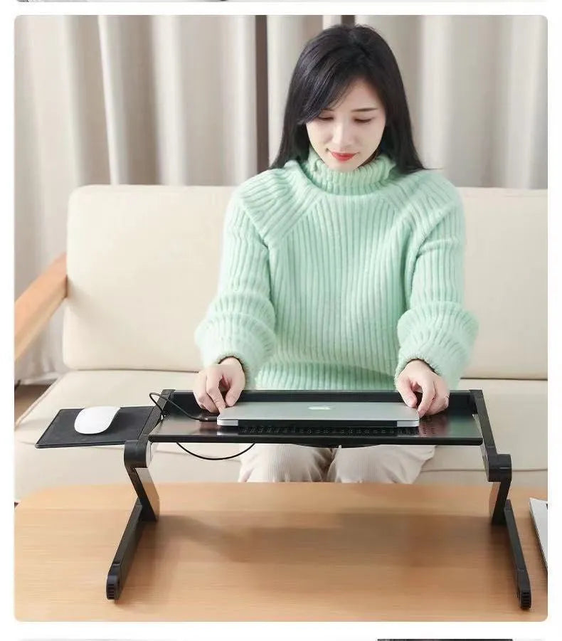 Folding black aluminium laptop cooling base with two fans and 1m power cord on a desk