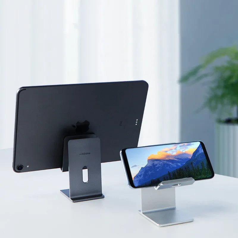 Dark Space Grey aluminium alloy mobile phone holder with adjustable lazy bracket arm and clamp on a wooden desk.