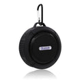 White waterproof Bluetooth speaker with a large clear suction cup on its back for wall mounting.
