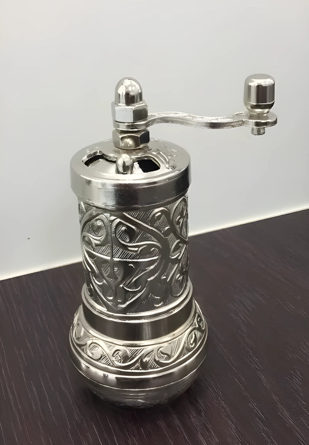 Small Turkish manual coffee grinder in silver with removable hand crank and ceramic burr