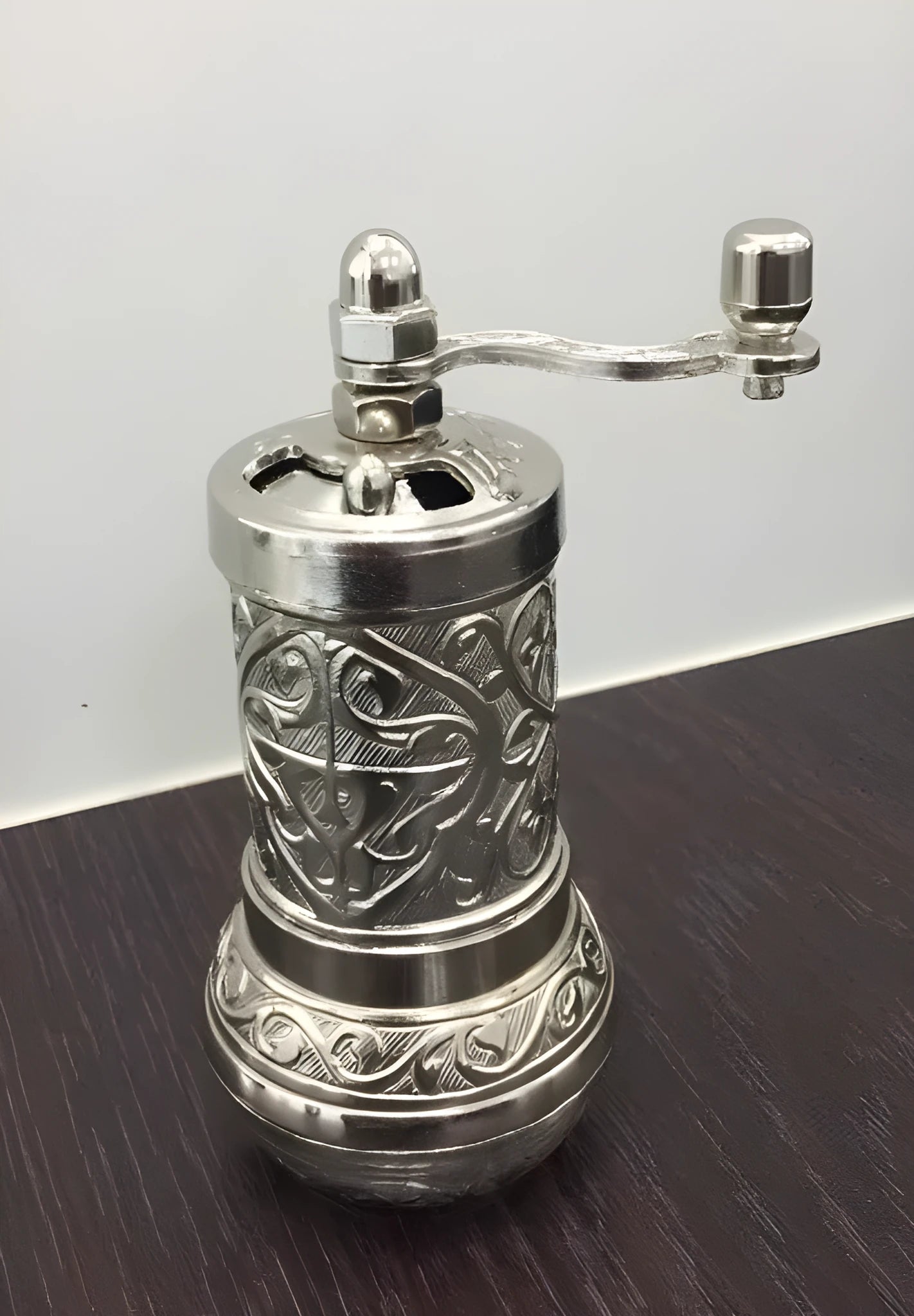 Small Turkish manual coffee grinder in silver with removable hand crank and ceramic burr