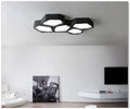 Geometric shaped iron wall light in black or white with remote control for dimming.