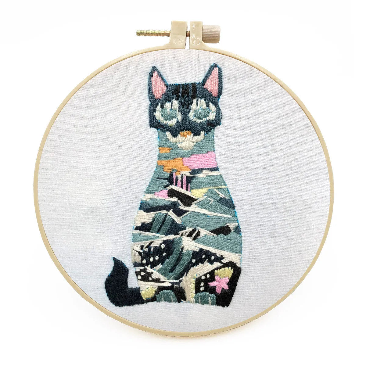 DIY embroidery kit components showing cotton fabric, coloured threads, and hoop for cat designs