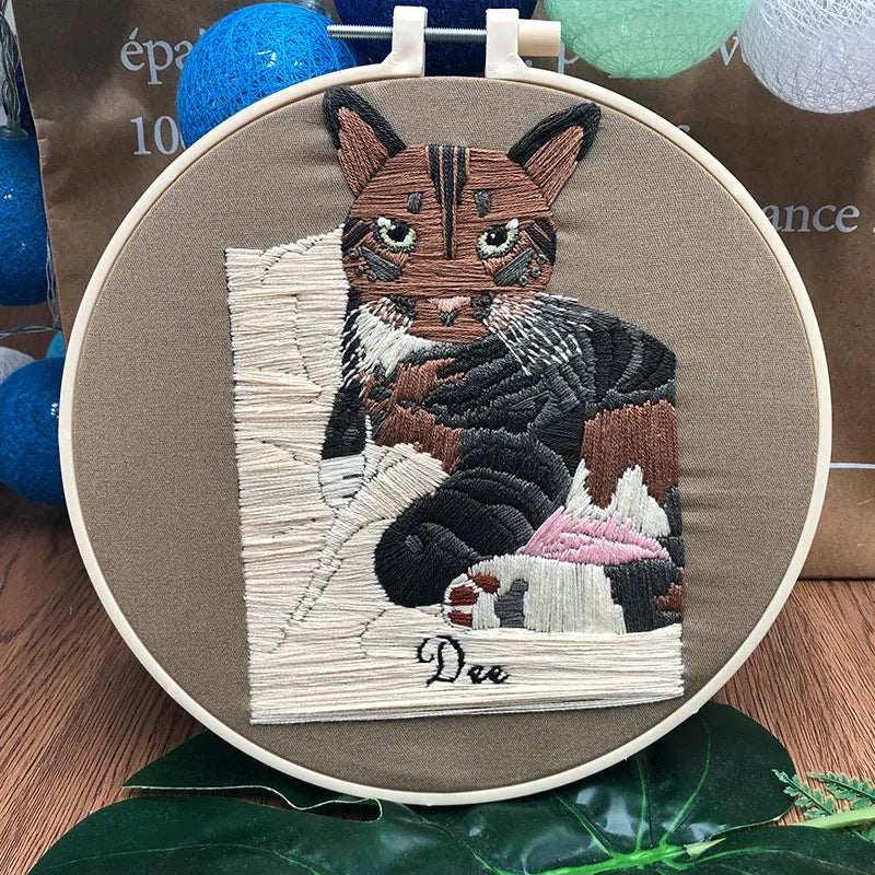 DIY embroidery kit components showing cotton fabric, coloured threads, and hoop for cat designs