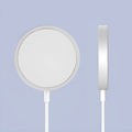 Silver metal Magsafe-compatible magnetic wireless charger for iPhone on a wooden table