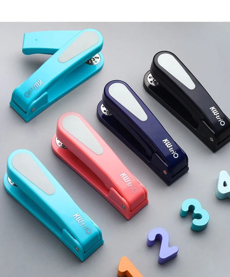 Black rotatable stapler with 360-degree rotating head on a desk next to stacked A4 paper.