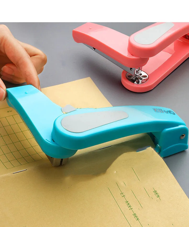 Black rotatable stapler with 360-degree rotating head on a desk next to stacked A4 paper.