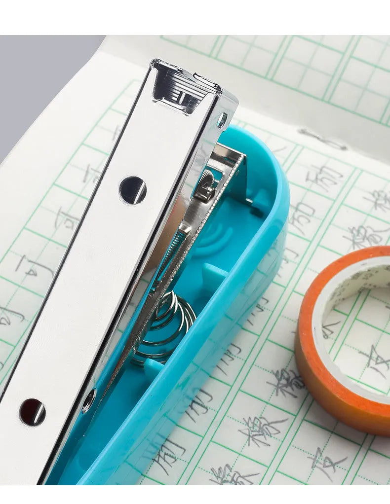 Black rotatable stapler with 360-degree rotating head on a desk next to stacked A4 paper.