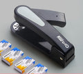 Black rotatable stapler with 360-degree rotating head on a desk next to stacked A4 paper.