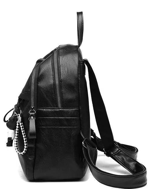 Black soft surface PU leather backpack with double straps, shown with a luggage strap accessory.