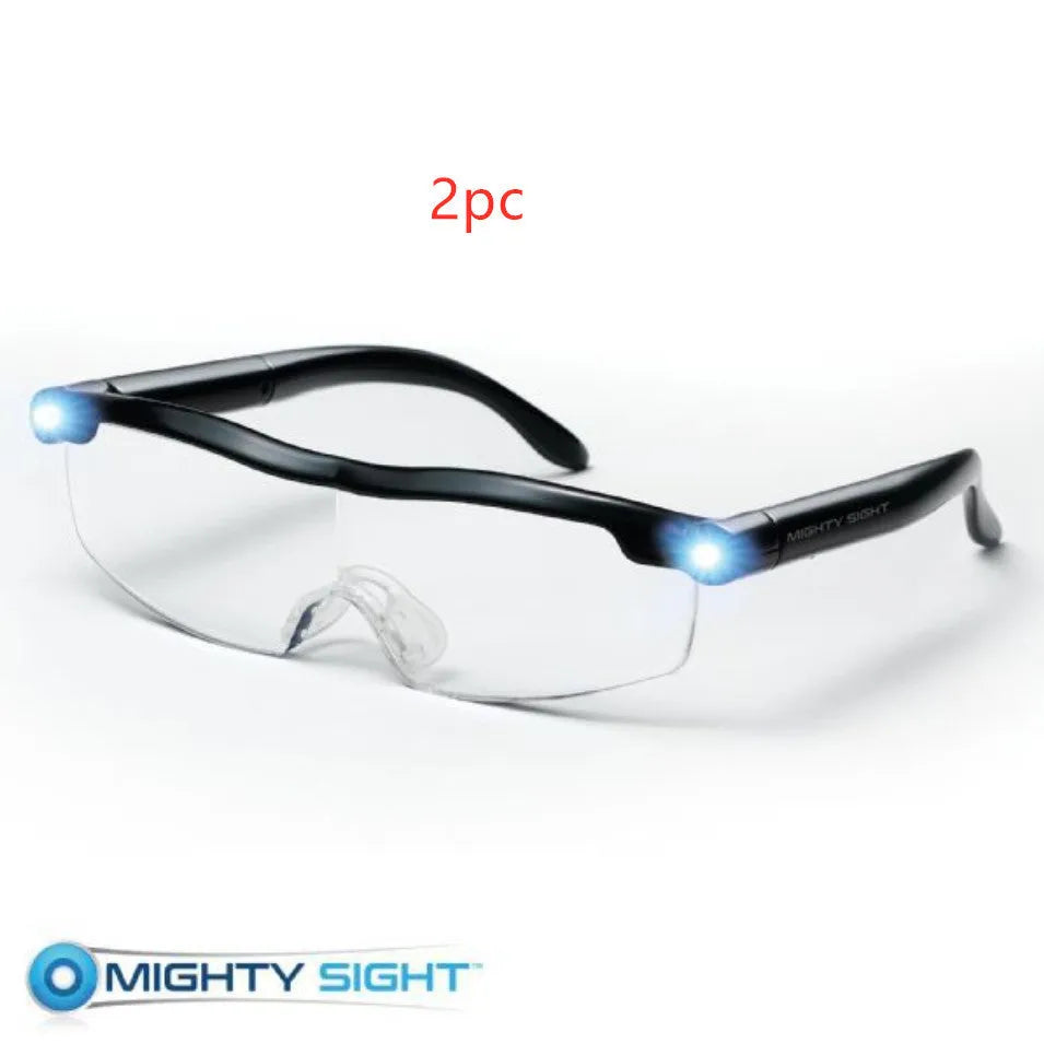 Transparent black USB rechargeable reading glasses with integrated LED light on a dark surface