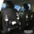 Black PU leather car seat back hanging organiser with pockets mounted on a car headrest.
