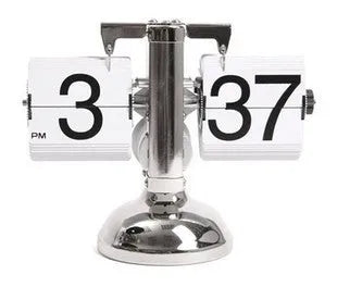 Small scale retro flip clock with black or white trim and black flip cards on a desk