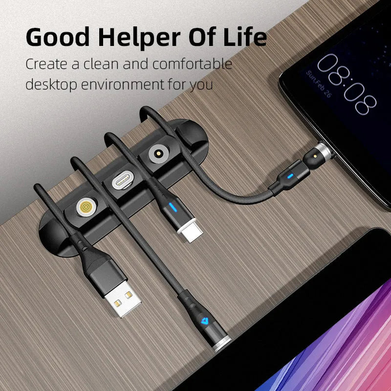 Black soft plastic desktop magnetic charging cable organiser on a desk.