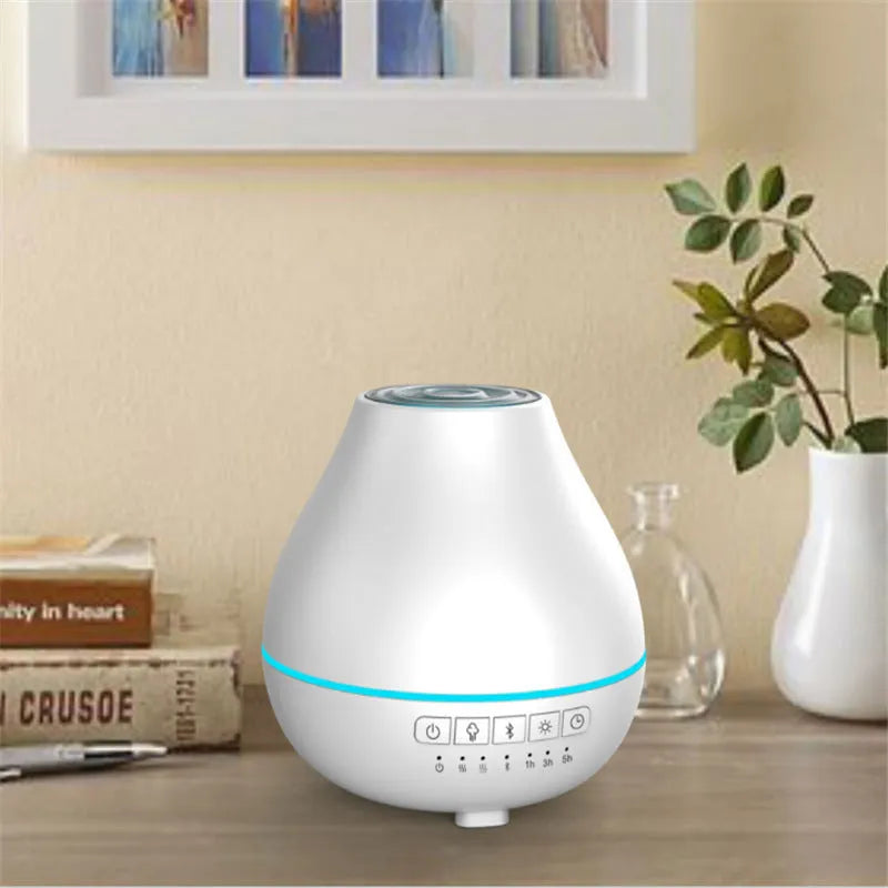 Round white Bluetooth humidifier and essential oil aroma diffuser with night light on a wooden surface.