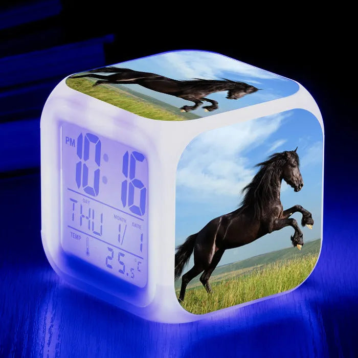 Small square plastic LED digital alarm clock showing time and temperature on a desk.
