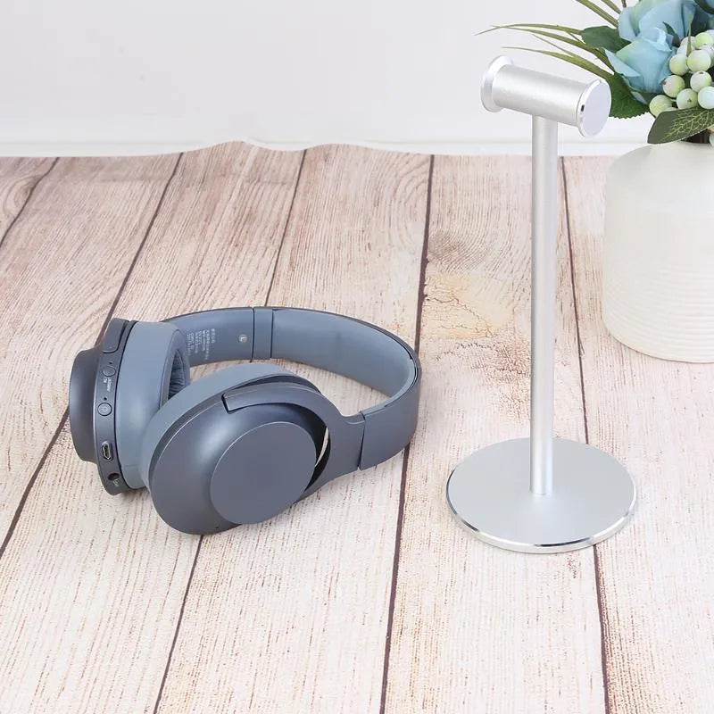 Black aluminium alloy headset bracket storage stand on a desk holding earphones