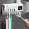 Automatic UV toothbrush steriliser with wall-mounted toothpaste squeezer in black or white
