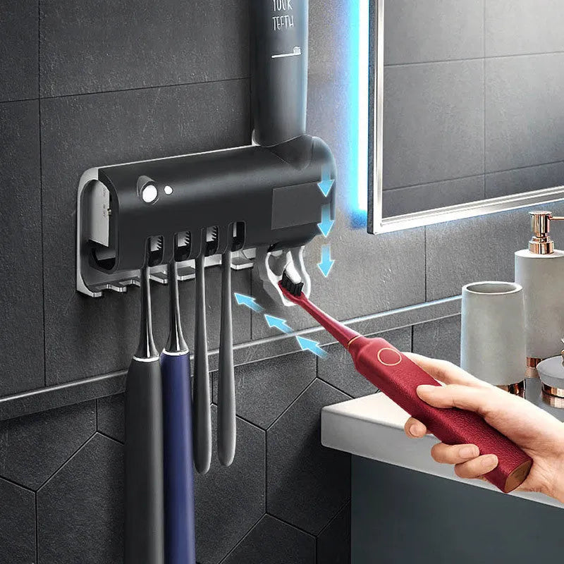 Automatic UV toothbrush steriliser with wall-mounted toothpaste squeezer in black or white