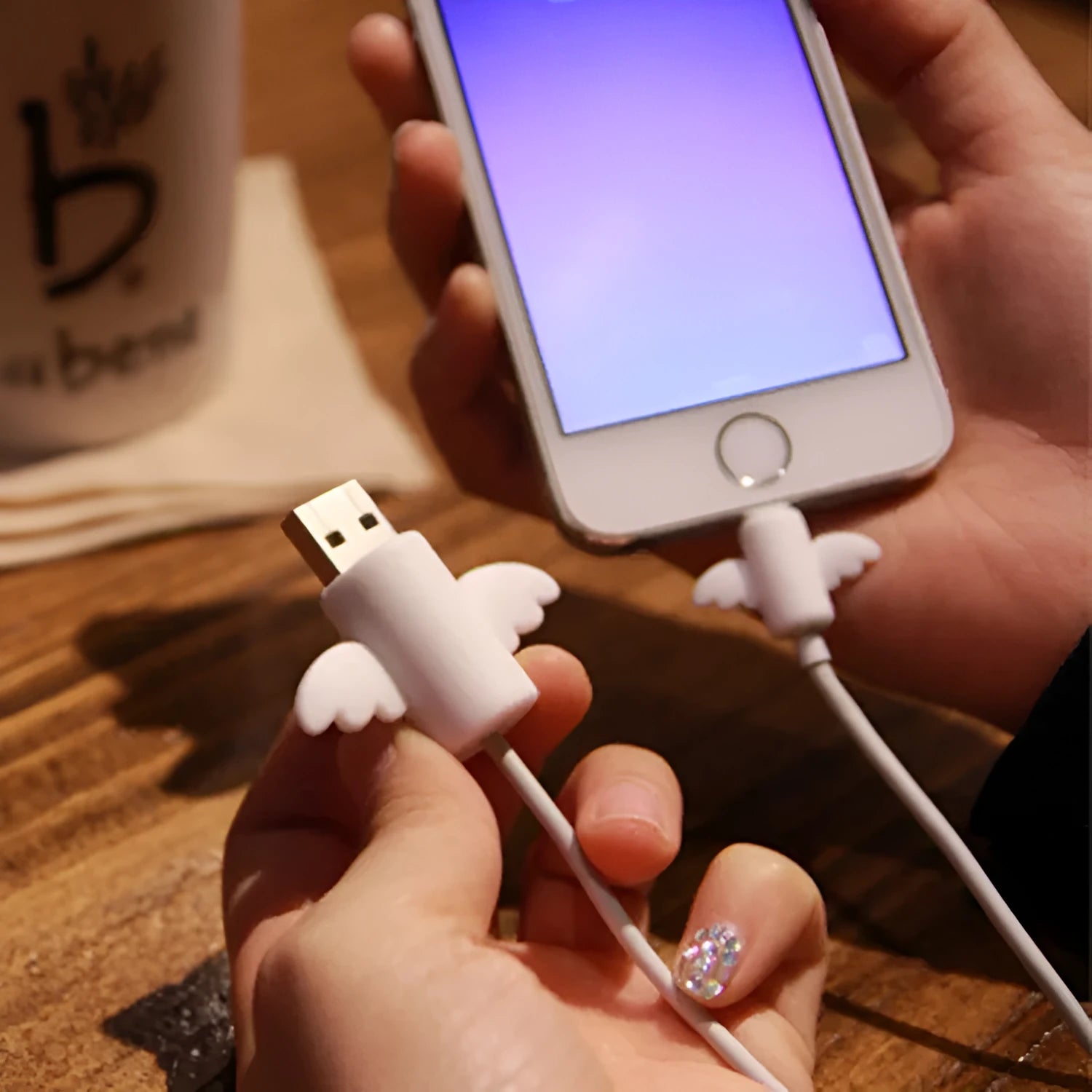White and black silicone cable protective covers shown next to a mobile phone charging cable