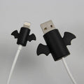 White and black silicone cable protective covers shown next to a mobile phone charging cable