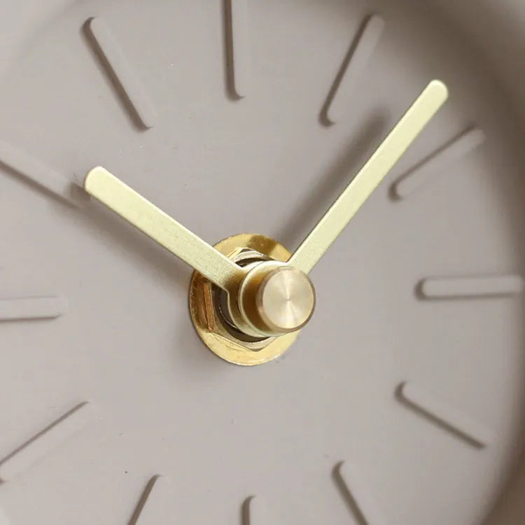 Round cement silent desk clock with Nordic minimalist design on wooden surface