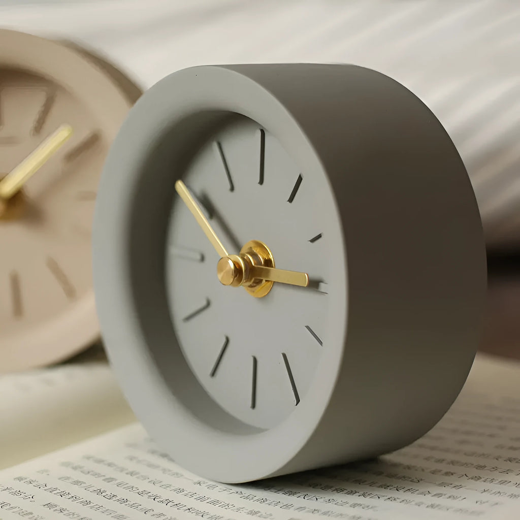Round cement silent desk clock with Nordic minimalist design on wooden surface