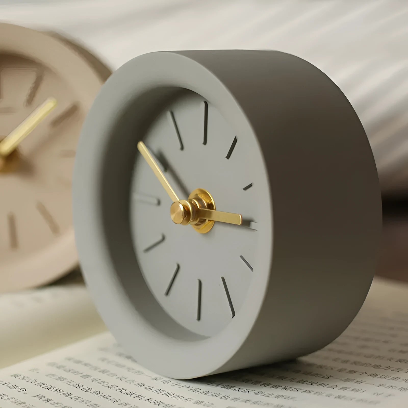 Round cement silent desk clock with Nordic minimalist design on wooden surface