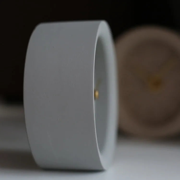 Round cement silent desk clock with Nordic minimalist design on wooden surface