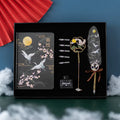 Chinese-style calligraphy gift set featuring a metal-sheathed feather pen, notebook, and collections of feather nibs.