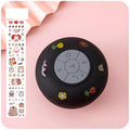 Small colourful waterproof Bluetooth mini speaker with a clear suction cup base mounted on a tile.