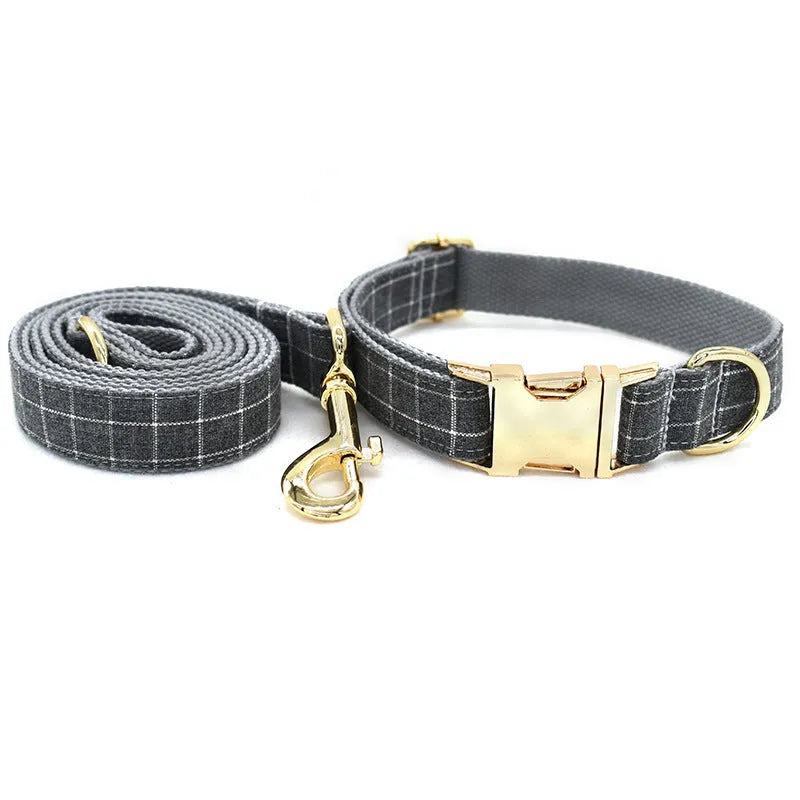 Grey plaid nylon dog collar with golden metal button on a white background, size M shown